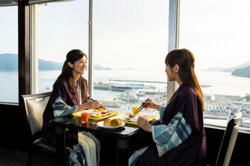 two women sitting at a table eating food in a restaurant at Todaya in Toba