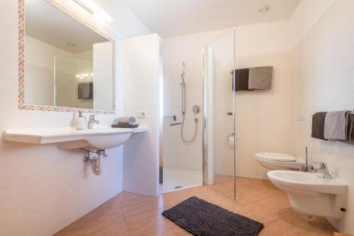 Un baño con lavabo, inodoro y ducha. en Schildberghof Santner, en Siusi