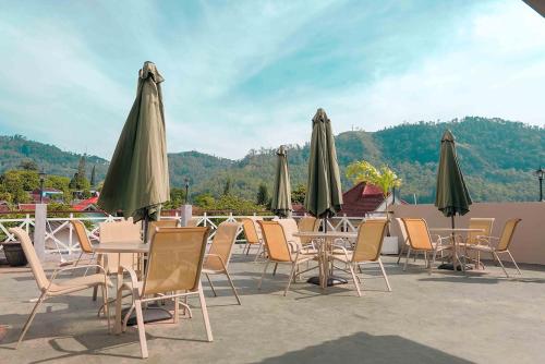 a group of tables and chairs with umbrellas at Rosetta Homestay in Batu