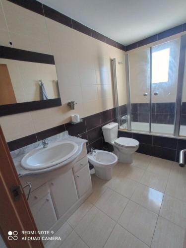 a bathroom with a sink and a toilet and a mirror at Mar azul in Almazora