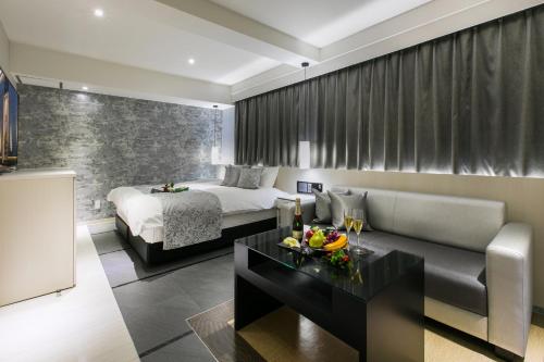 a hotel room with a bed and a couch and a table at HOTEL 粋 in Fukuyama