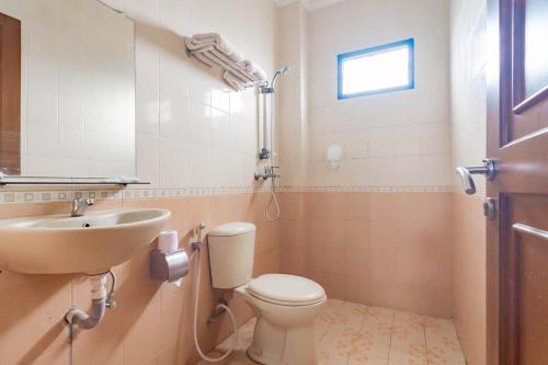 ein Bad mit einem WC und einem Waschbecken in der Unterkunft Cihampelas Hotel 2 Mitra RedDoorz in Bandung