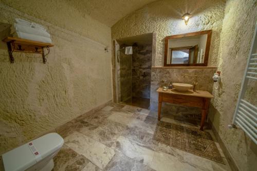 a bathroom with a toilet and a sink and a mirror at Seki Cave Suites in Goreme