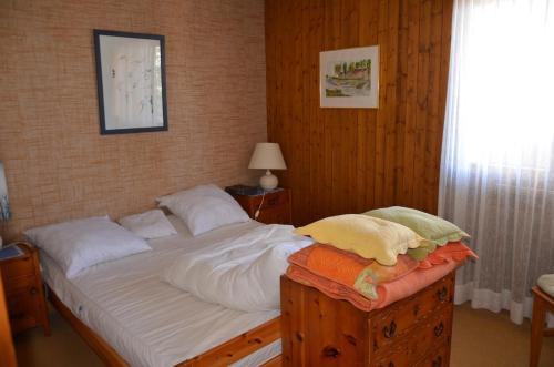 a bedroom with a bed with white sheets and a window at Immeuble Mont Noble in Les Collons