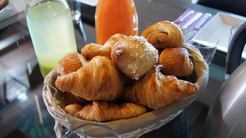 einen Korb mit Croissants und anderem Gebäck auf dem Tisch in der Unterkunft Domaine de la Planche de Melussac in Cussac-sur-Loire