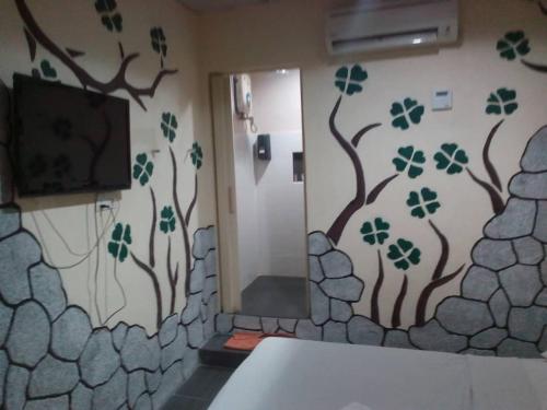 a bathroom with a shower with trees painted on the wall at Golden Leaf Hotel Danga Bay in Johor Bahru