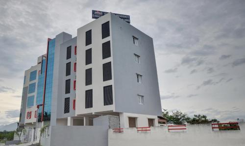 a white building with black windows on the side of it at Treebo Everest Residency Tidel Park, 15 Mins From Coimbatore International Airport in Coimbatore
