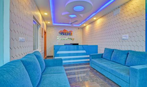 a lobby with blue couches and a bar at Treebo Everest Residency Tidel Park, 15 Mins From Coimbatore International Airport in Coimbatore
