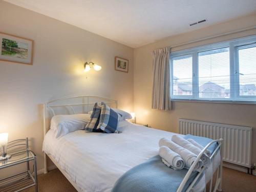 1 dormitorio con 1 cama con sábanas blancas y ventana en Taverner - Self catering holiday home close to Poole Quay, en Poole