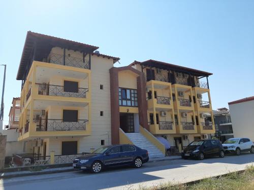 two cars parked in front of a building at Hotel Kosmas in Sarti