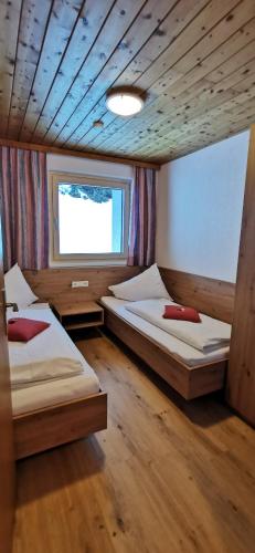 a bedroom with two beds and a window at Ledererhof Apartments in Sankt Jakob in Defereggen
