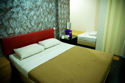 a bedroom with a large bed with a red headboard at Golden Leaf Hotel Danga Bay in Johor Bahru