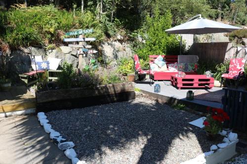 a patio with a table and chairs and an umbrella at Tulloch (2 Hamilton Place) in Kyle of Lochalsh