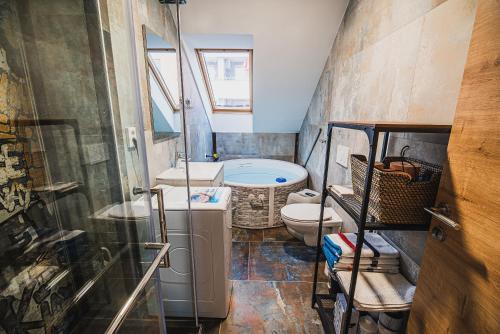 a bathroom with a toilet and a sink and a tub at Apartment VAZATAOR with sauna in Brežice
