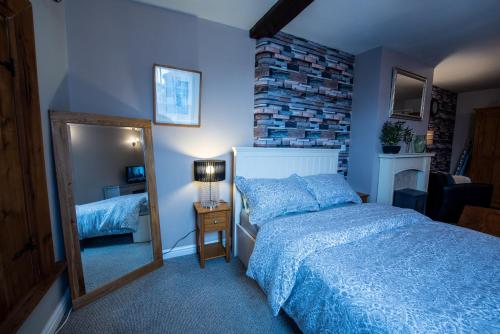a bedroom with a large bed and a mirror at The Little Pheasant Apartment Ironbridge Gorge in Broseley