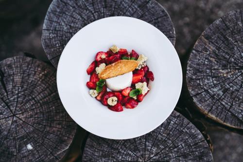 a bowl of food with strawberries and cream on a table at Pflugwirts Hotel und Gasthaus in Oberkirch