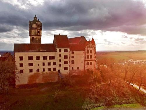 a large castle with a lighthouse on top of it at Hotel Zur Krone in Ronneburg