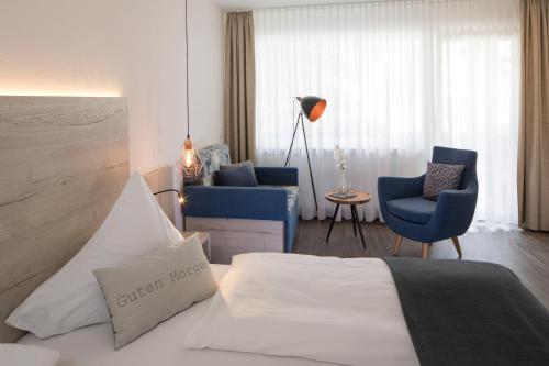 ein Hotelzimmer mit einem Bett und zwei Stühlen in der Unterkunft Hotel Rössle in Alpirsbach