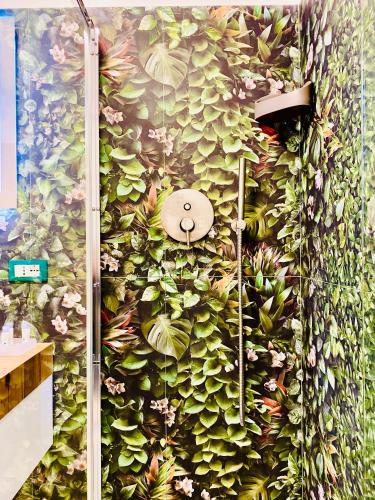 a wall covered in plants in a bathroom at Nima Oberdan House in Perugia