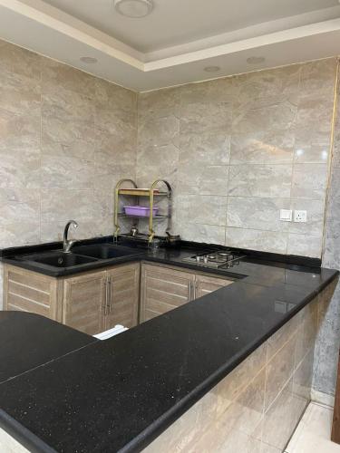 a kitchen with a black counter top and a sink at Aqaba Roza in Aqaba