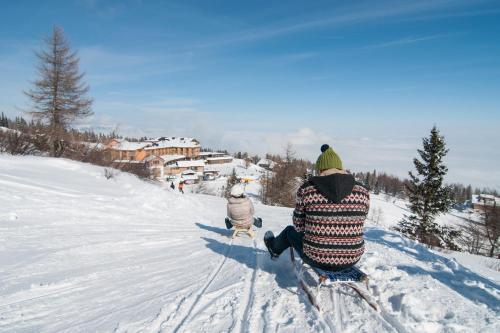 a couple of people on skis in the snow at Feriendorf Berghof in Villach