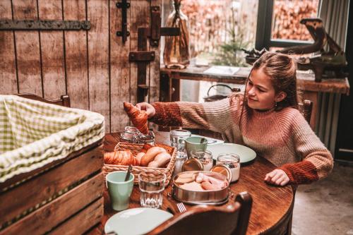 a young girl sitting at a table eating food at CRASH'NSTAY - 't Silo Huis in Sprang-Capelle