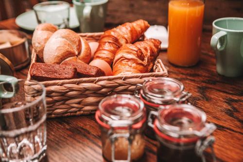 a basket of bread and pastries on a wooden table at CRASH'NSTAY - 't Silo Huis in Sprang-Capelle