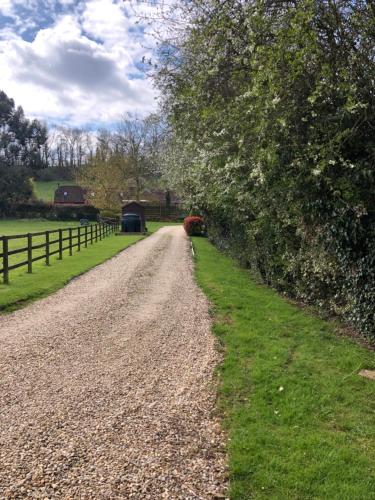 a gravel road next to a fence and grass at Wisteria Cottage - Hillside Holiday Cottages, Cotswolds in Warmington