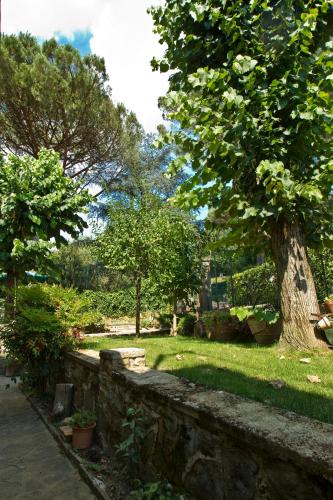 a garden with a stone wall and a tree at Residenza Ruggini in Florence