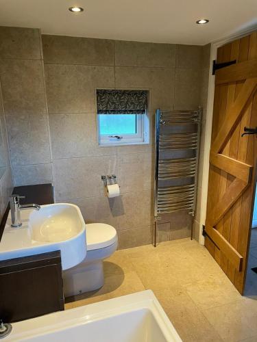 a bathroom with a sink and a toilet and a shower at Wisteria Cottage - Hillside Holiday Cottages, Cotswolds in Warmington