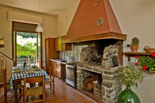 a kitchen with a large stone fireplace with a table at Residenza Ruggini in Florence