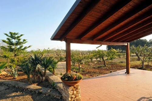 a patio with a wooden roof and some plants at La Capasa B&B in Sannicola