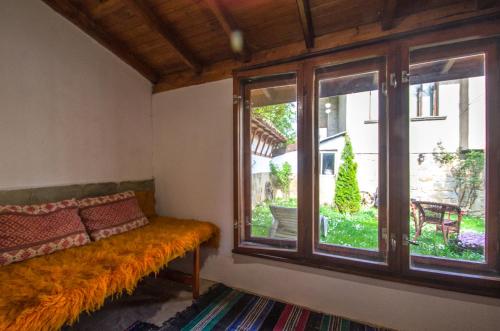 ein Zimmer mit einem Sofa und einem großen Fenster in der Unterkunft Къща за гости Виктория in Kotel