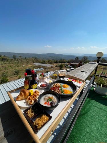 a table filled with food on top of a roof at บ้านไร่ระเบียงฟ้า น้ำหนาว แคมป์ปิ้ง in Ban Phu Hi