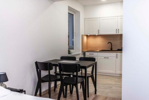 uma cozinha com uma mesa preta e cadeiras pretas em Apartamenty Kwiatowa w Szczawnicy BEZPŁATNY PARKING em Szczawnica