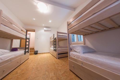 Habitación con 3 literas y pasillo. en City Hostel Trogir, en Trogir