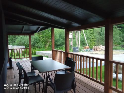 a screened in porch with a table and chairs at Chalet Venterivka in Tatariv