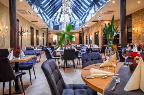 restauracja ze stołami i krzesłami oraz szklanym sufitem w obiekcie Hotel Diament Plaza Katowice w mieście Katowice