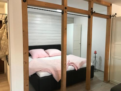 a bedroom with a four poster bed with pink pillows at Ferienwohnung Watzmannblick & Hallenbad in Berchtesgaden