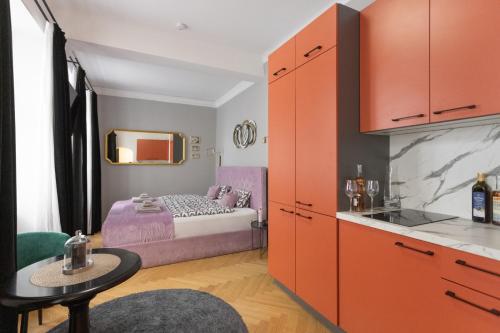 a kitchen with orange cabinets and a small bedroom at Old Town Vienna in Vienna