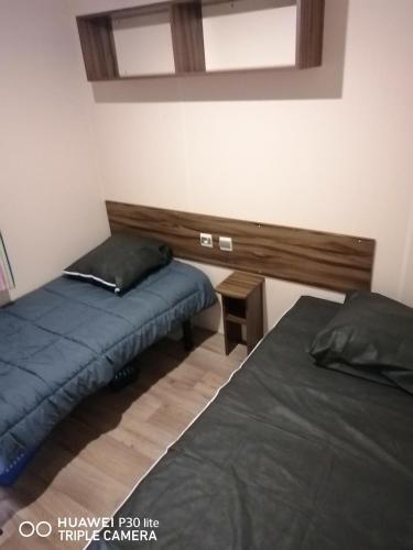 une chambre avec deux lits et un miroir au mur dans l'établissement Bungalow cosy à Onzain avec terrasse & piscine partagée, à Onzain