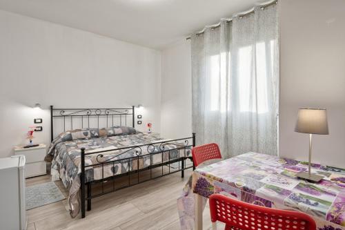 a bedroom with a bed and a table and chairs at Venice Pink House in Marghera