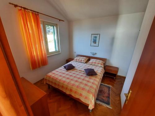 a small bedroom with a bed and a window at Apartments Rose in Lokva Rogoznica