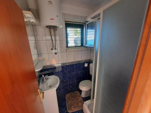 a small bathroom with a toilet and a sink at Apartments Rose in Lokva Rogoznica