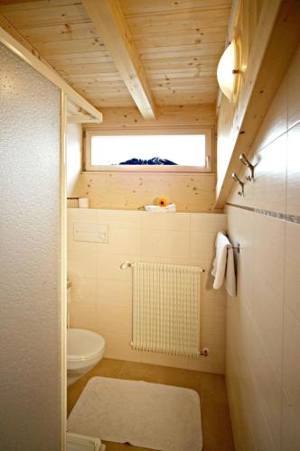 a small bathroom with a toilet and a window at Garni Reutlingen in Colfosco