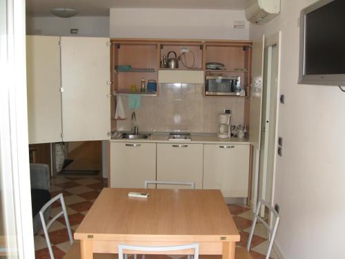a kitchen with a wooden table and a table and chairs at Grand Hotel Liberty in Riva del Garda
