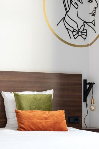 a bed with a wooden headboard with a picture of a woman at Alex Maastricht in Maastricht