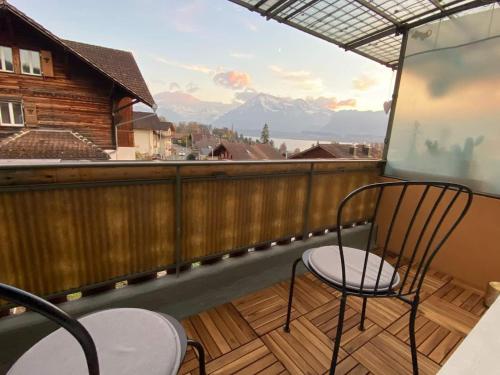 a balcony with a chair and a view of a mountain at Schöne Ferienwohnung mit Seeblick in Thun
