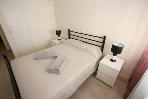 a bedroom with a bed with two towels on it at Apartment Rocha Sol in Portimão