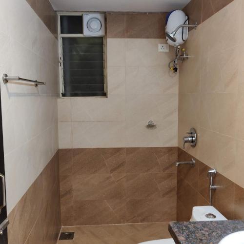 a bathroom with a shower with a toilet and a window at Studio Apartment by Leela Homes in Arpora